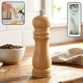 Wooden manual pepper grinder for fresh spice seasoning on kitchen tabletop