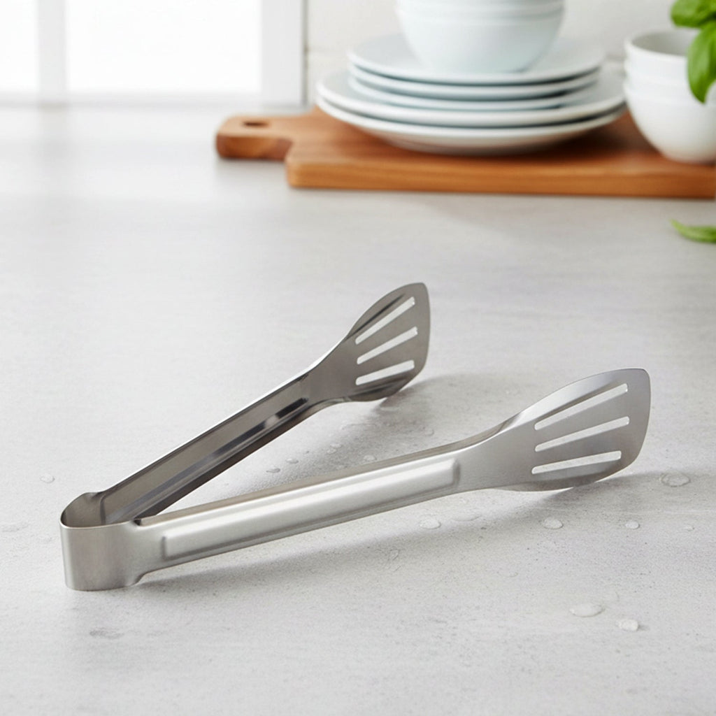 Serving tongs laid next to plates, ideal for serving snacks and salads