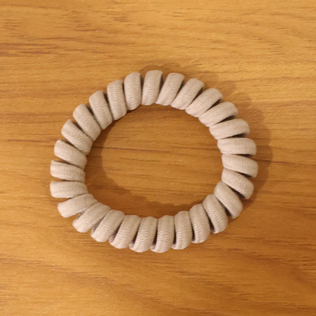Multiple spiral coil hair bands in assorted shades, offering versatile styling.