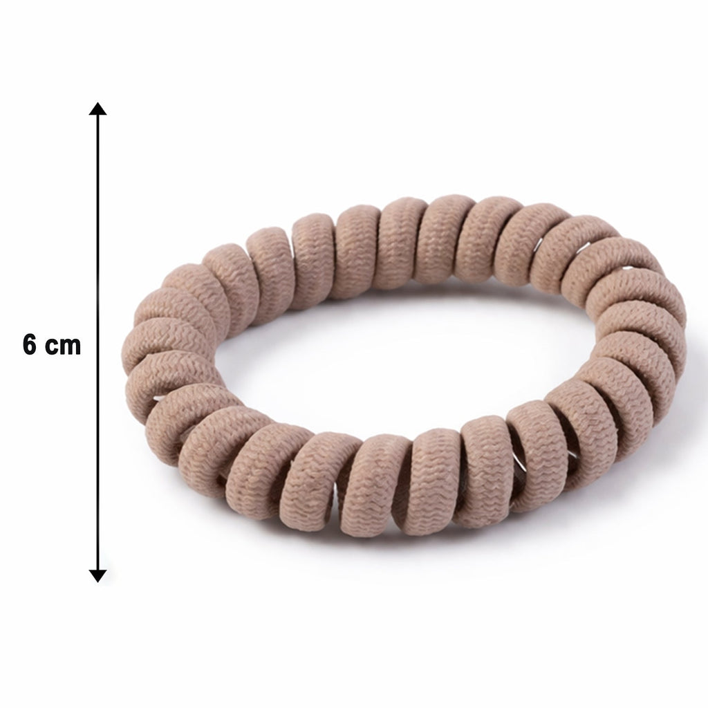 A single spiral coil hair band presented on a flat surface.
