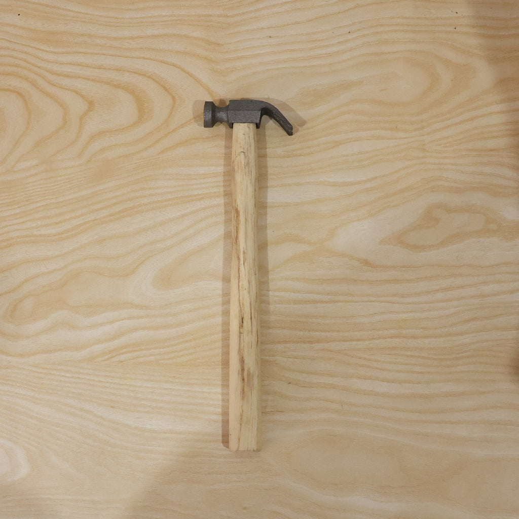 Person using claw hammer to drive a nail in carpentry