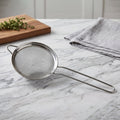 Stainless steel tea strainer with fine mesh and long handle for kitchen use