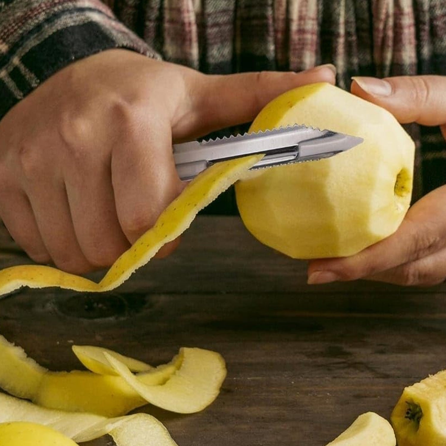 Close-up of the sharp stainless steel blades and peeler from the kitchen knife set.