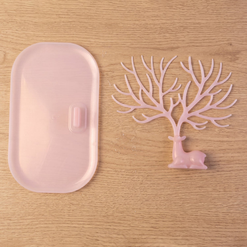 Pink deer jewelry stand with earrings displayed, India