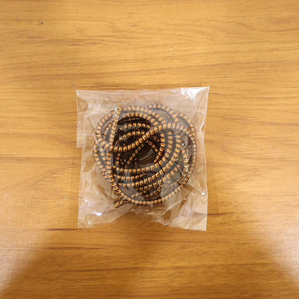 Spiral cable protector sleeve in use, neatly wrapping a cable on a desk.