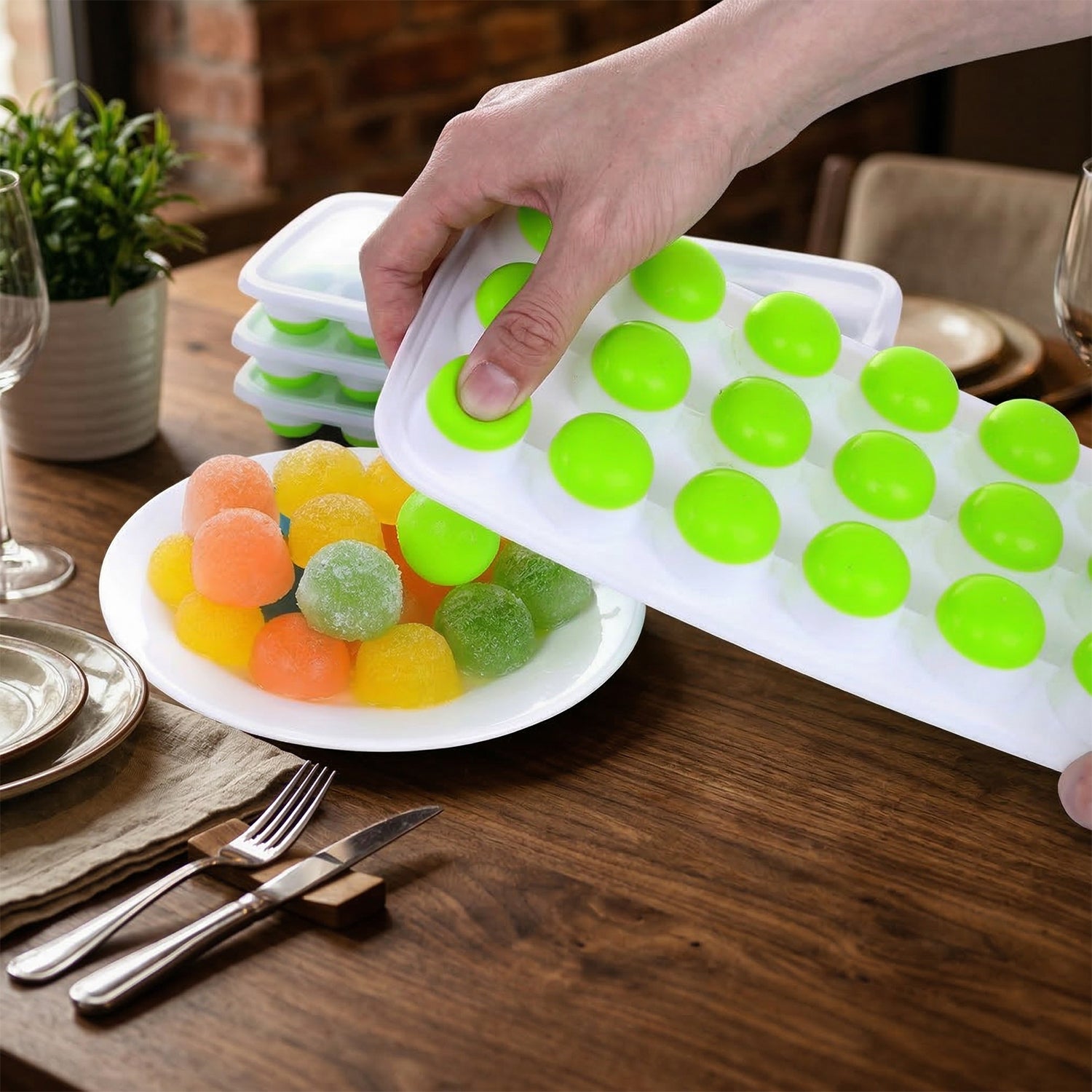 Flexible plastic ice cube mold being twisted to easily release round ice cubes.