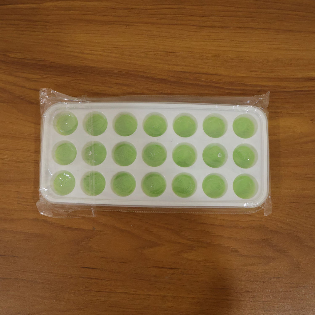 Close-up of the plastic ice cube tray's round molds, ready for filling.