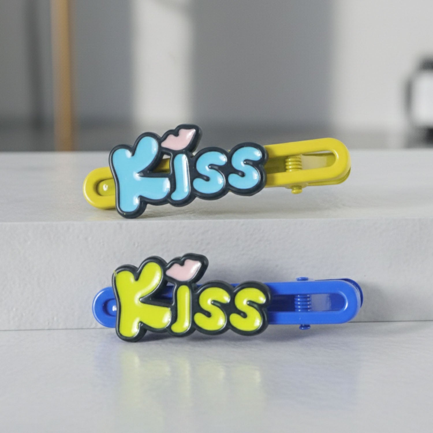 Close-up of cartoon letter Kiss hair pins in a 2-piece set