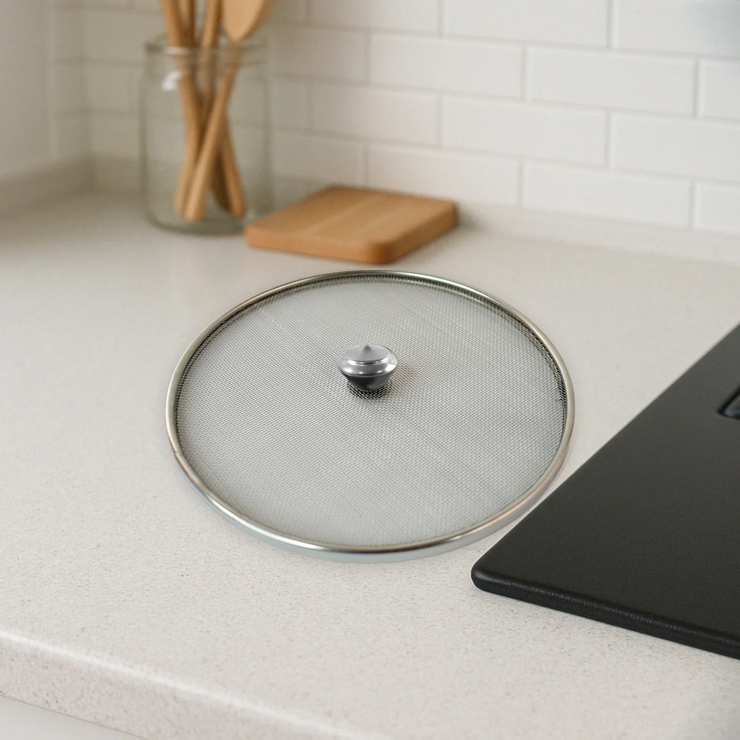 Reusable stainless steel mesh splatter guard lid for frying pans.