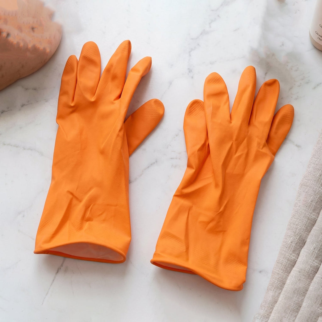 Reusable orange rubber household cleaning gloves laid out
