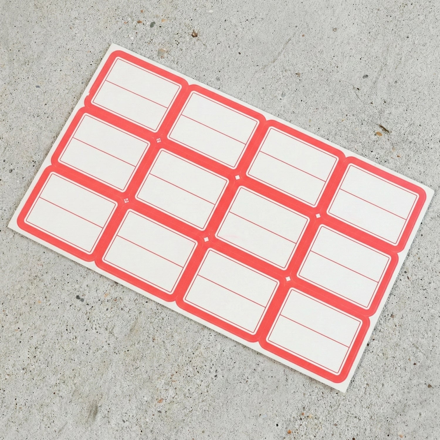 Close-up view of red and white rectangular self-adhesive label stickers