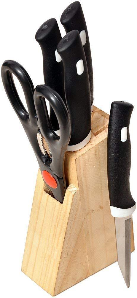 Stainless steel kitchen knives set with black handles arranged on wooden block