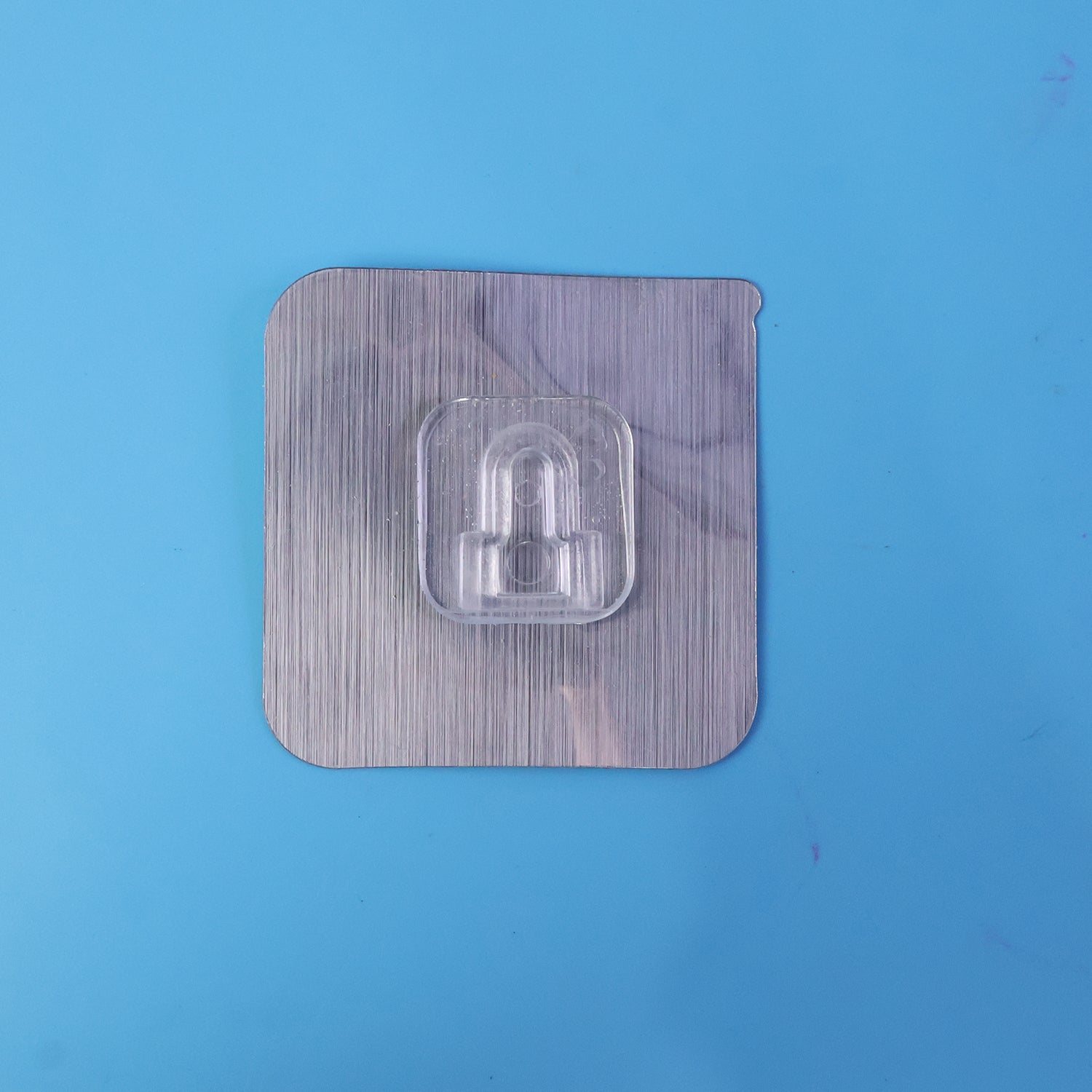 Transparent double sided self adhesive wall hook in use.