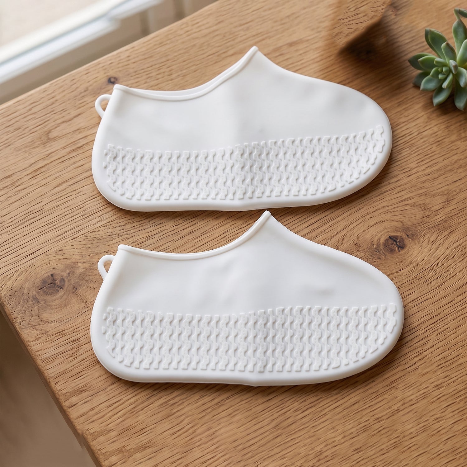 Textured sole detail of the small white waterproof rain shoe cover for grip.