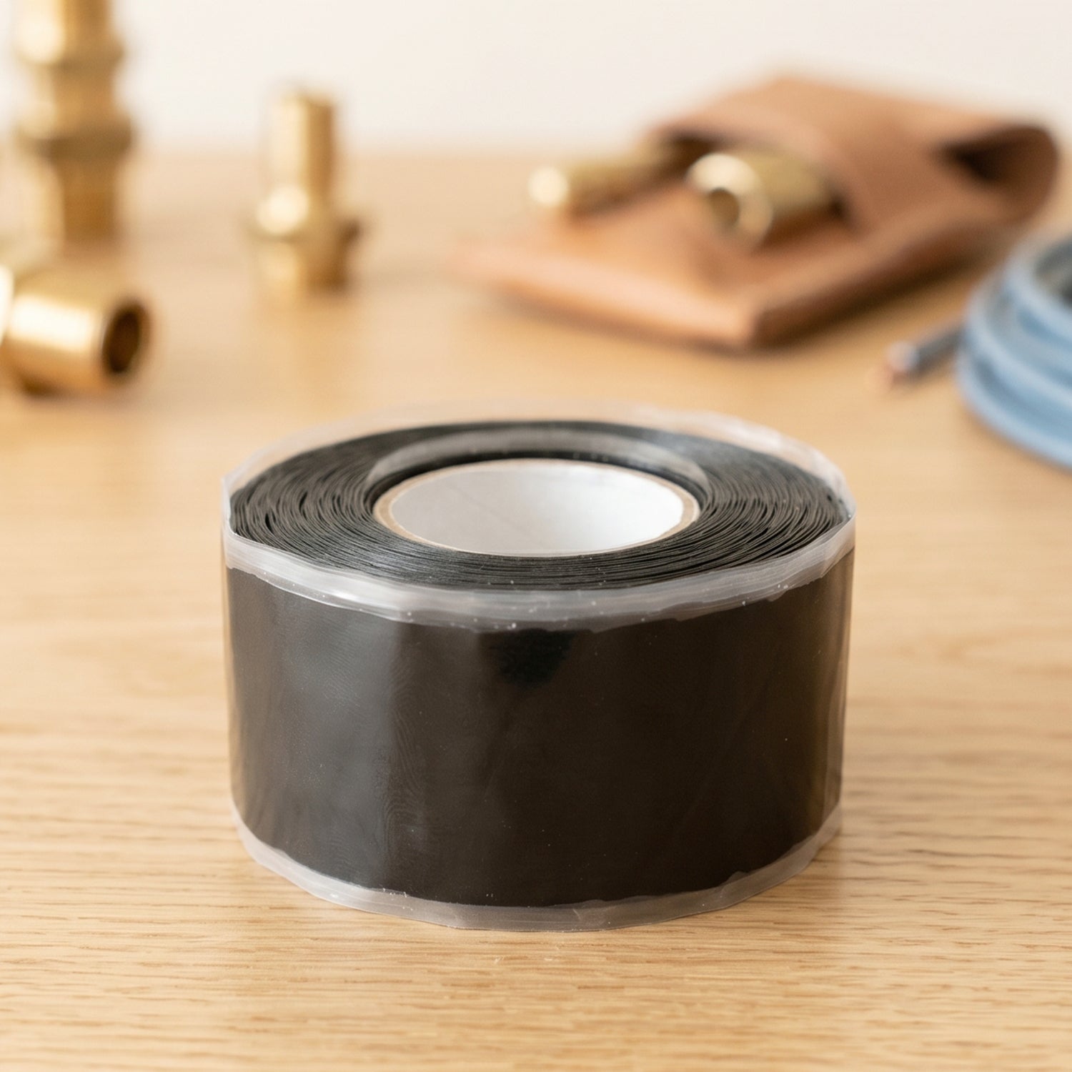 Black silicone repair tape wrapping around a garden hose